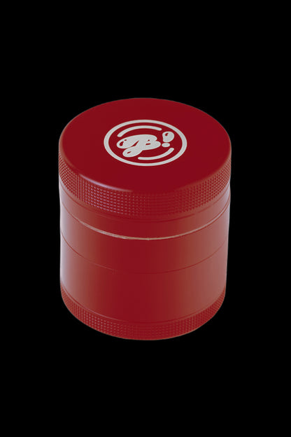 Red four-piece cannabis grinder with a silver logo.