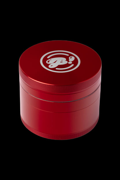 Red four-chamber grinder with a logo on top.