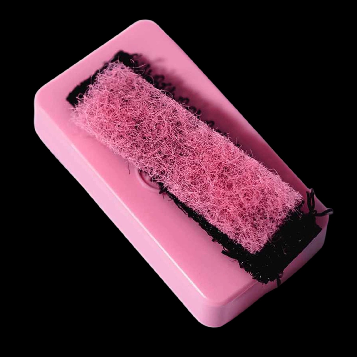 Close-up angled view of a pink Blazy Susan Resin Blaster Magnetic Scrubber showing its fuzzy pink scouring pad seated in a glossy rectangular base against a black background