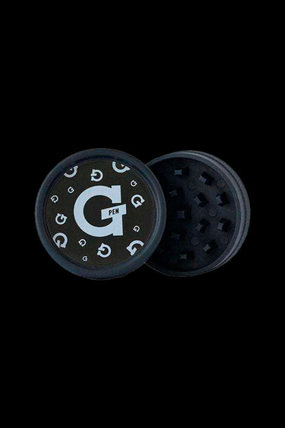 Open cannabis grinder with a black exterior and white "G Pen" logo, revealing the ground herb compartment.