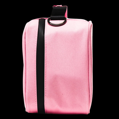 Close-up front view of the pink Blazy Susan Stash Bag showing its black vertical zipper strip and metal D-ring tab against a black background