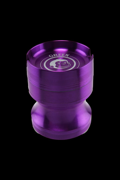 Angled top-down view of the purple Green Monkey Chacma Grinder with Ashtray showing its recessed ashtray rim and smiling logo inside.