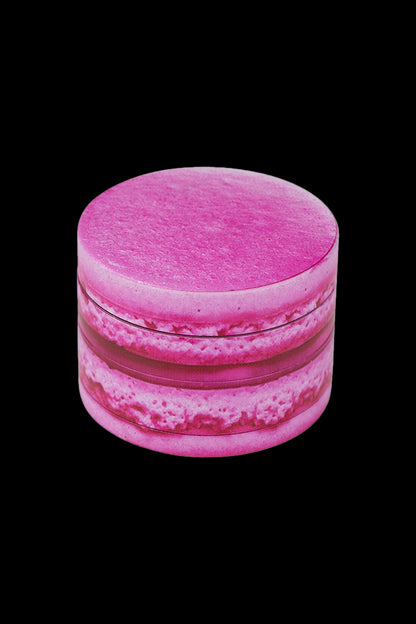 Pink cannabis grinder on a black background.