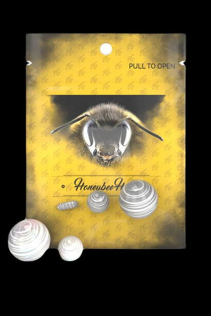 Yellow packaging for “Honeybee” cannabis accessories, featuring a close-up of a bee’s face and scattered, metallic filter tips.
