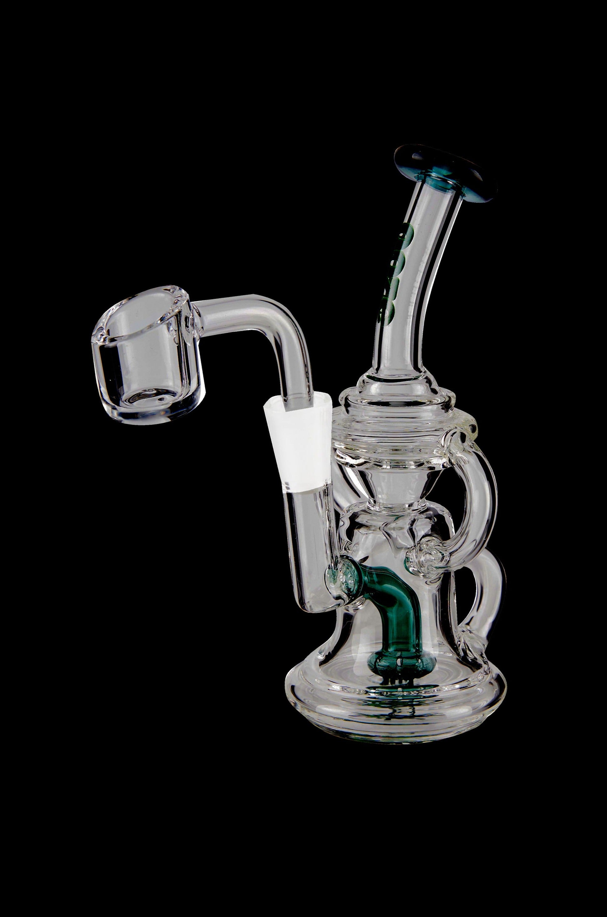 Clear glass dab rig with green accents and a quartz banger, isolated on a black background.
