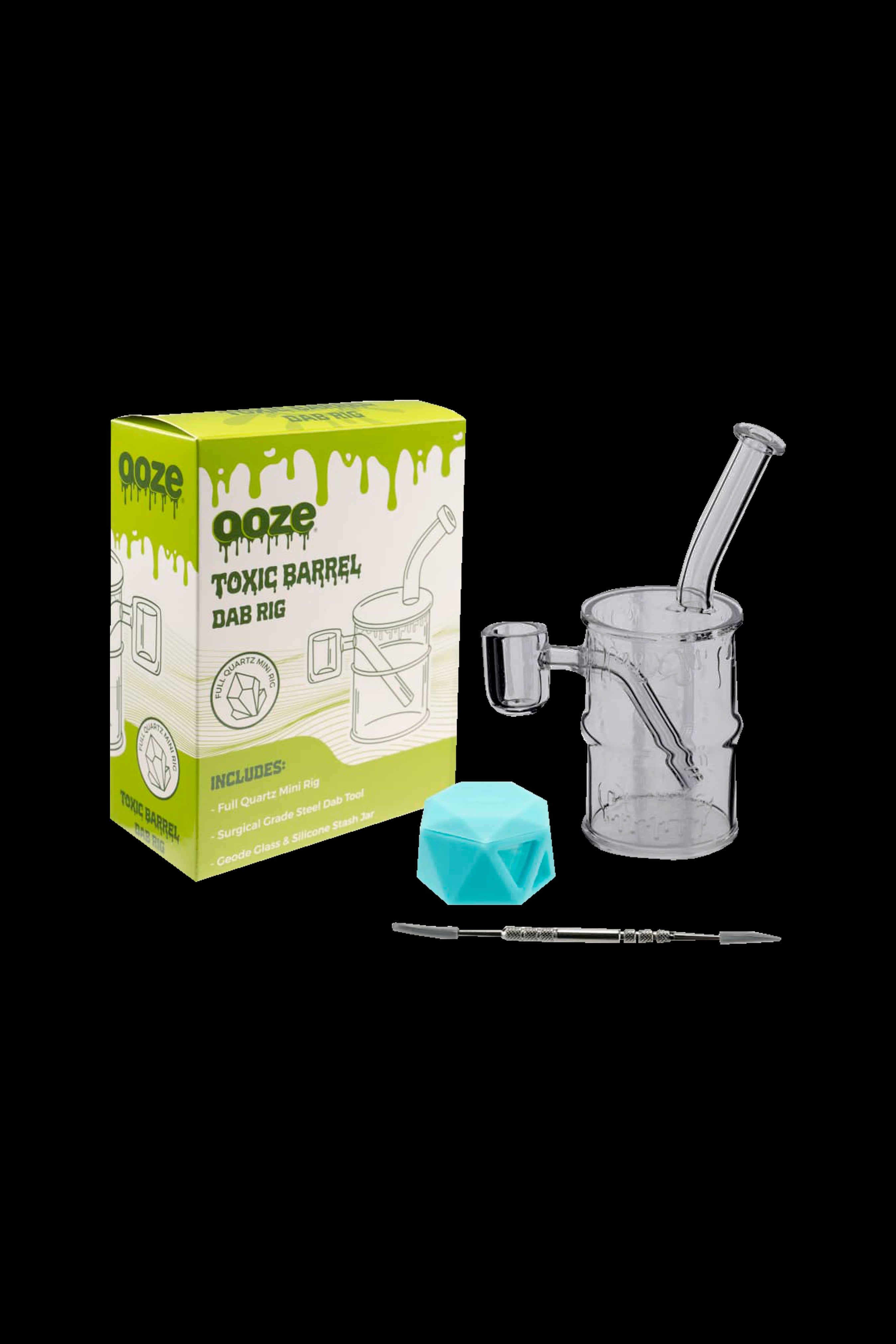 Ooze Toxic Barrel dab rig kit with glass water pipe, quartz banger, dab tool, and blue ice cube cooling insert, displayed with its packaging.