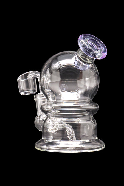 Clear glass dab rig with quartz banger, isolated on a black background.