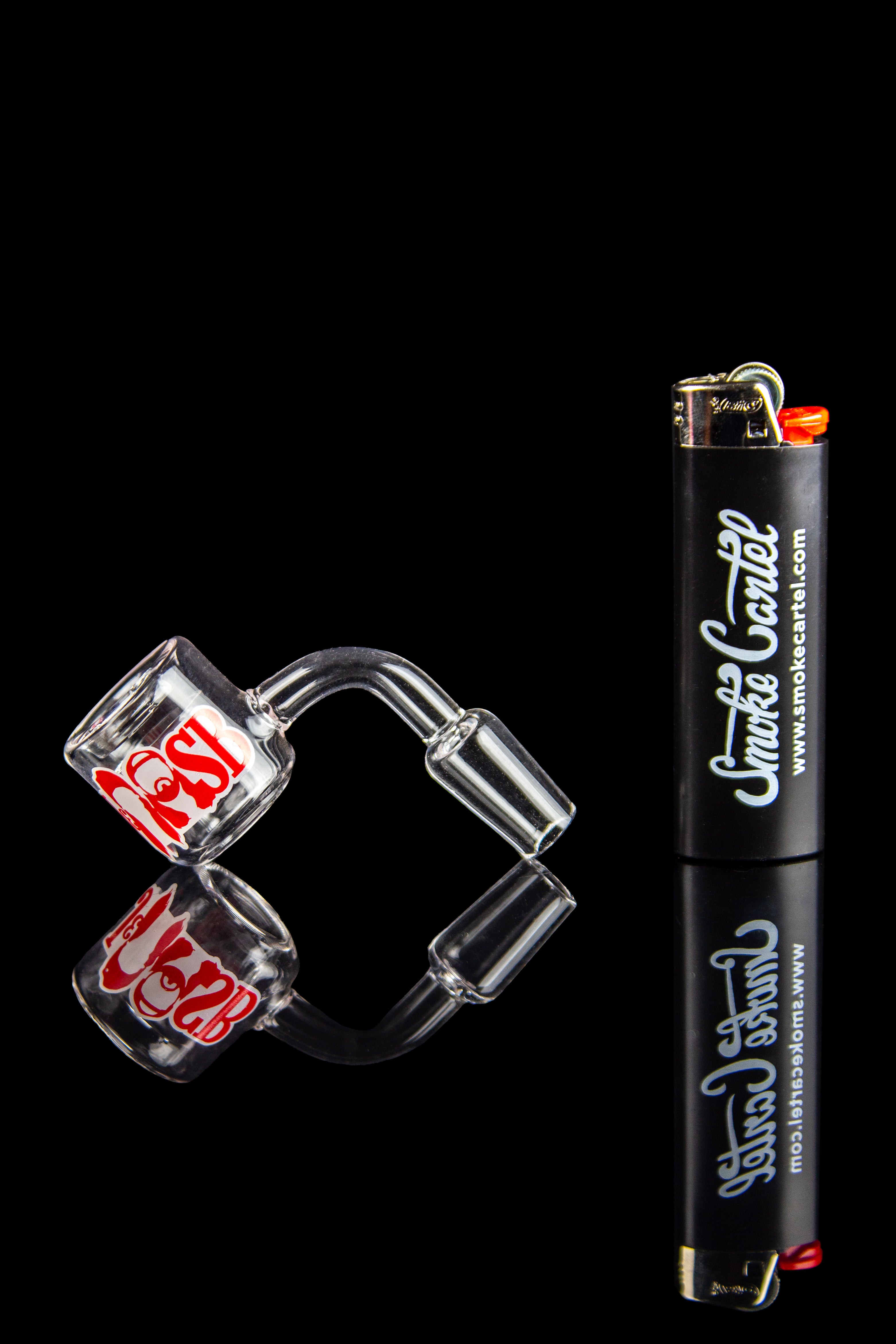 Glass dab rig and lighter against a black background.