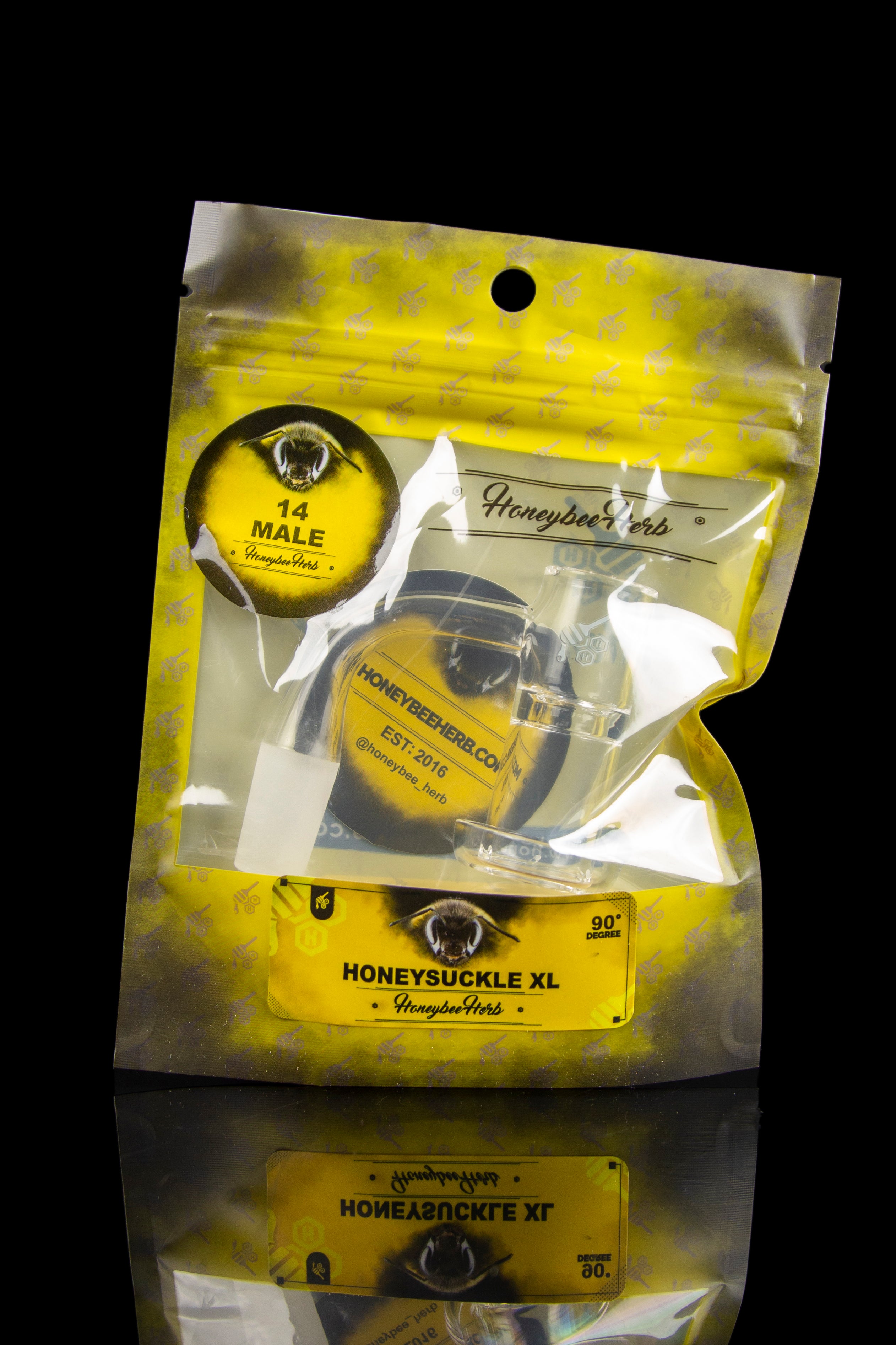 Silver mylar bag with cannabis branding, featuring an eye graphic and “Honeysuckle XL” text, with a website address and established date.