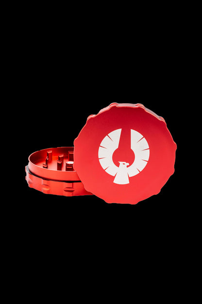 Red cannabis grinder with a white phoenix logo, partially disassembled.