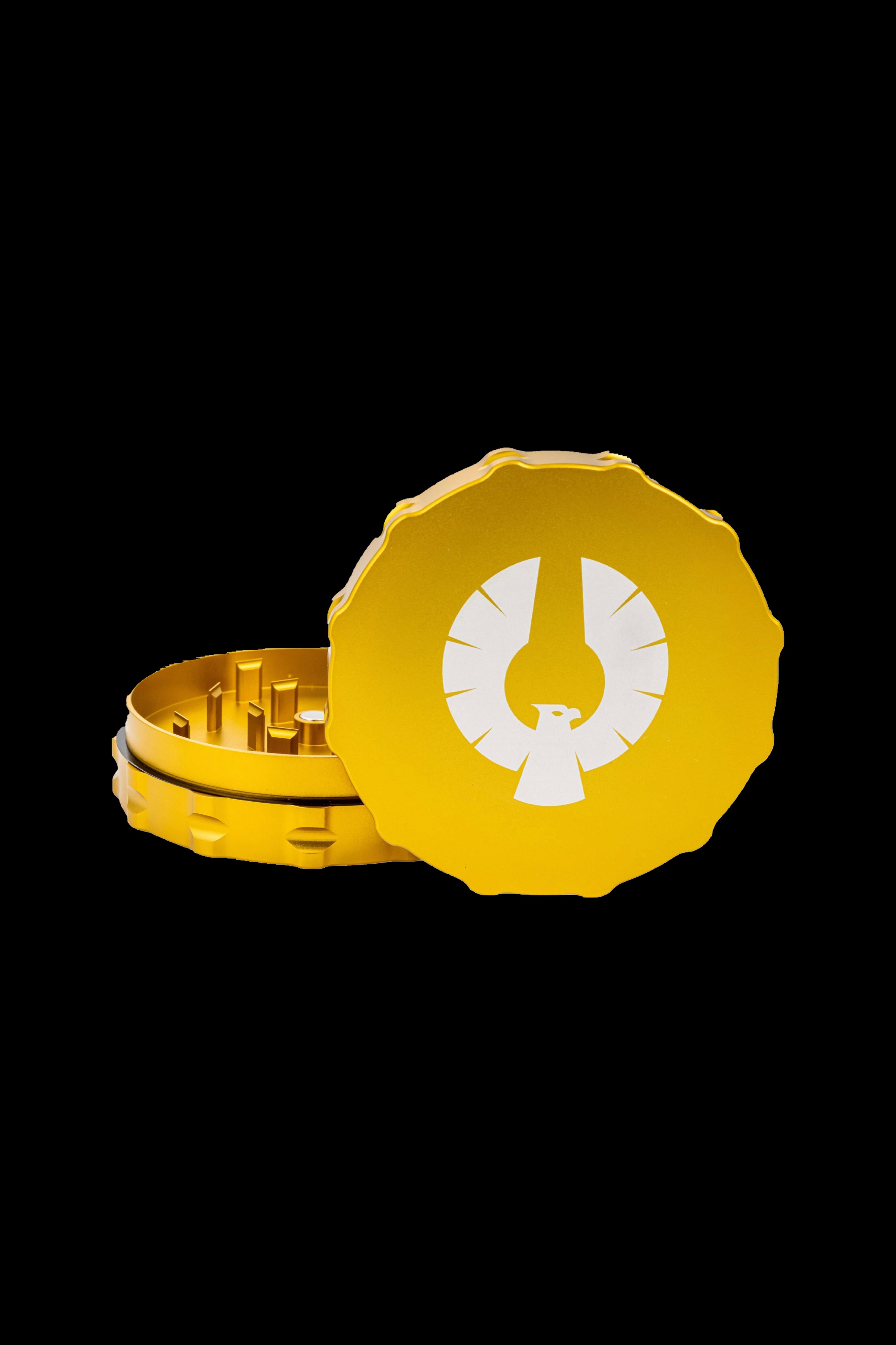 Gold cannabis grinder with a stylized phoenix logo.