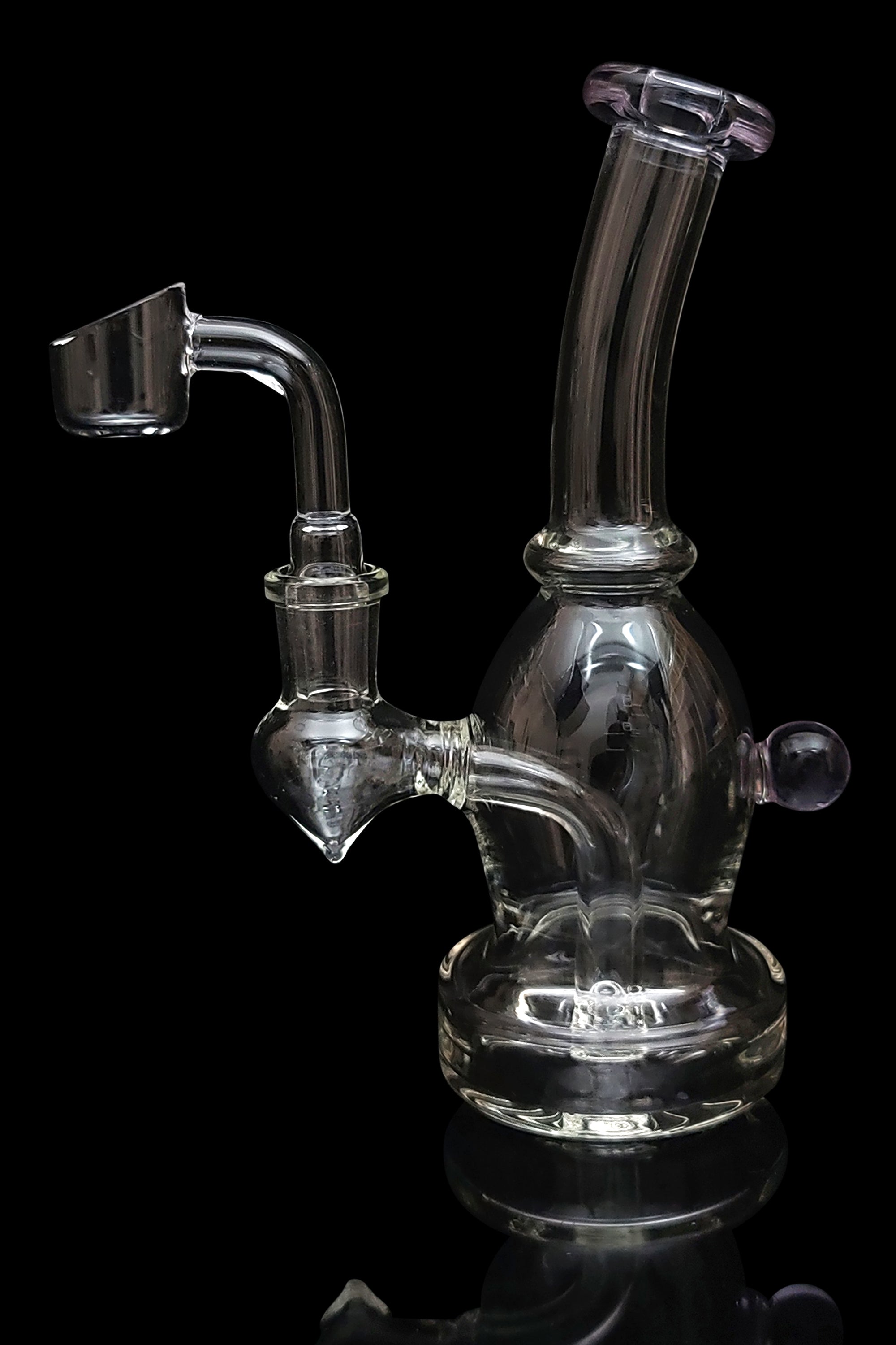 Clear glass dab rig with a quartz banger, isolated on a black background.