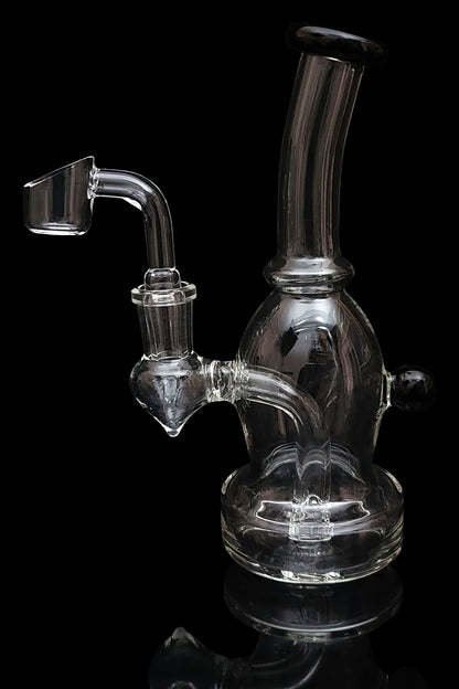 Clear glass dab rig with a quartz banger, isolated on a black background.