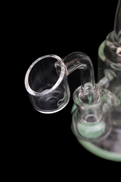 Clear glass dab rig with a visible quartz insert against a black background.