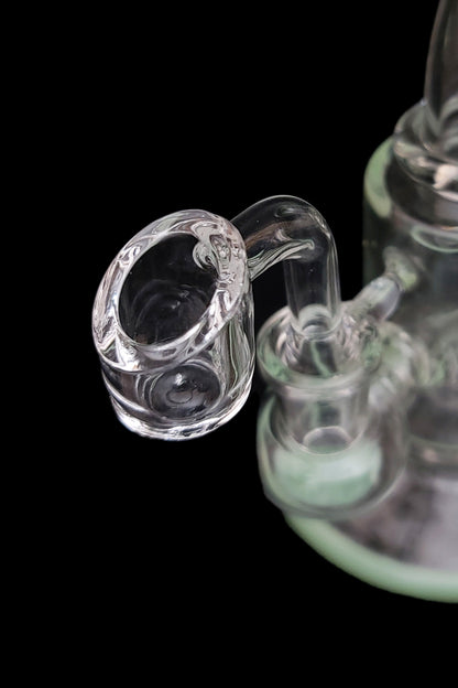 Close-up of a glass bong with a clear bowl piece against a black background.