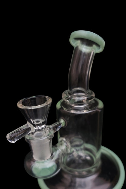 Mint green glass bubbler and bowl against a black background.