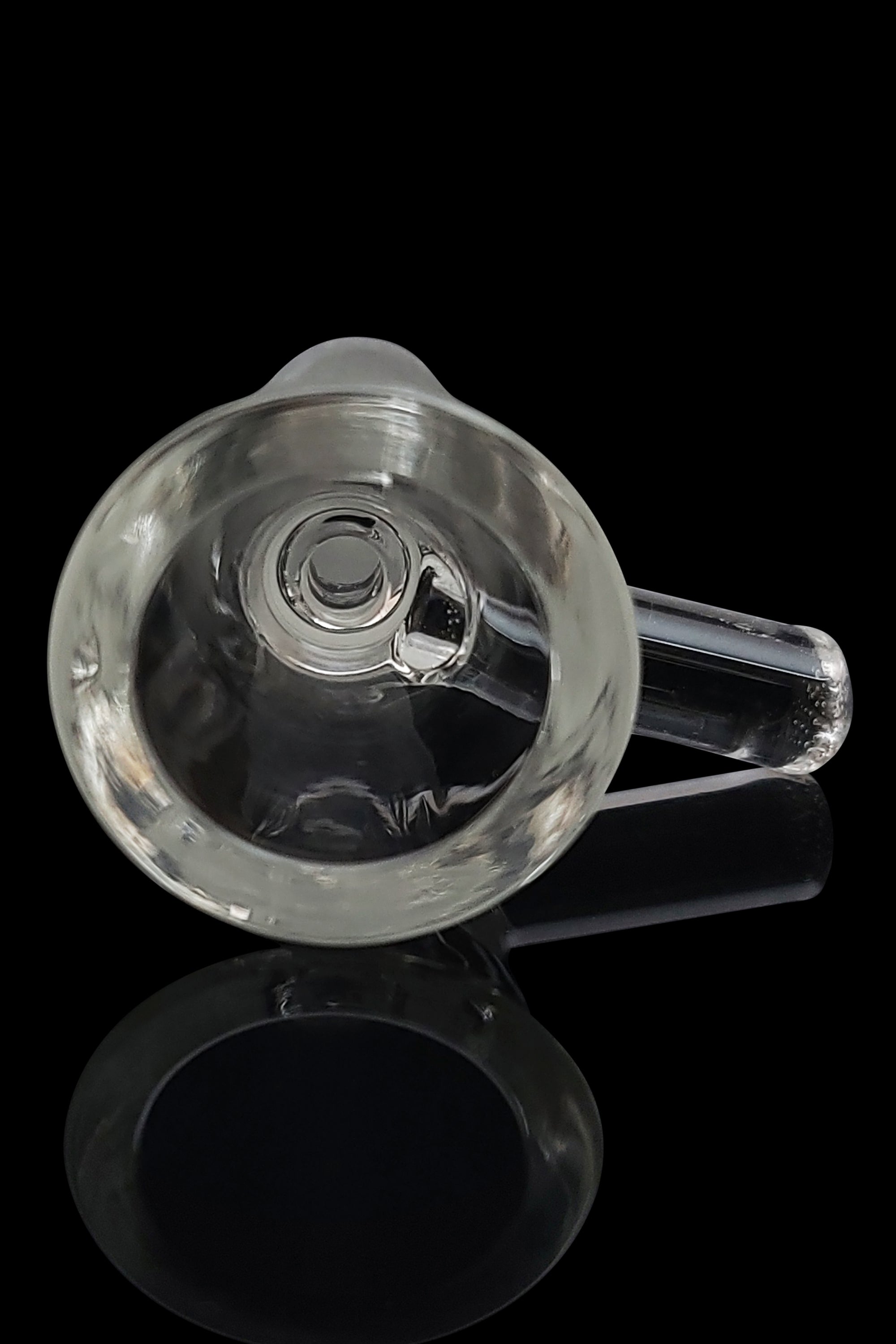 Clear glass bubbler with a visible bowl and mouthpiece, reflecting on a dark surface.