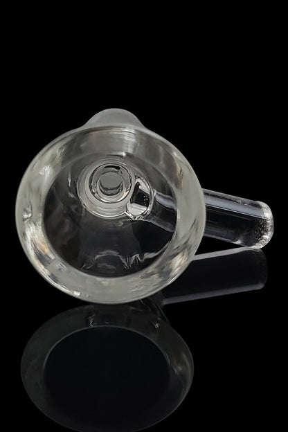 Clear glass bubbler with a visible bowl and mouthpiece, reflecting on a dark surface.