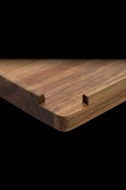 Wooden rolling tray with slots for rolling papers, isolated on black.