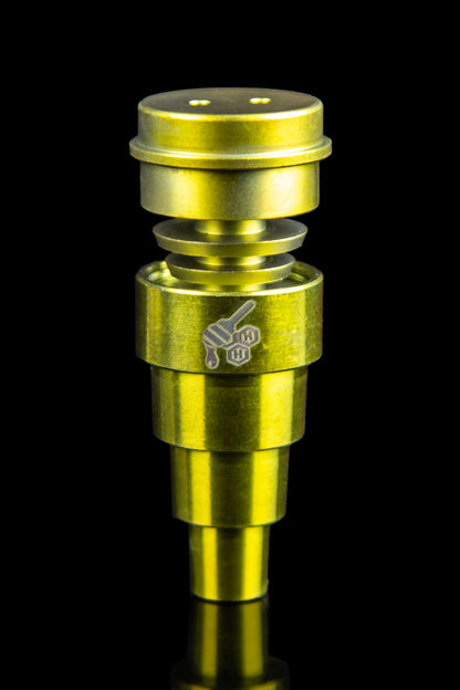Gold-colored dab rig nail with stacked tiers and engraved logo, isolated on black.