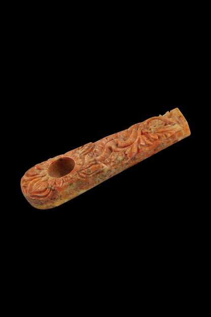 A close-up, angled view of the Marble Stone Pipe with Flower Design, showcasing its textured surface and detailed floral carvings.