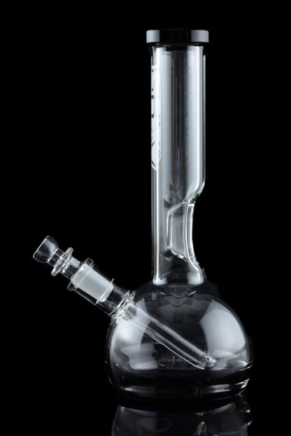 Clear glass water pipe (bong) with a rounded base and cylindrical neck, isolated on a black background.
