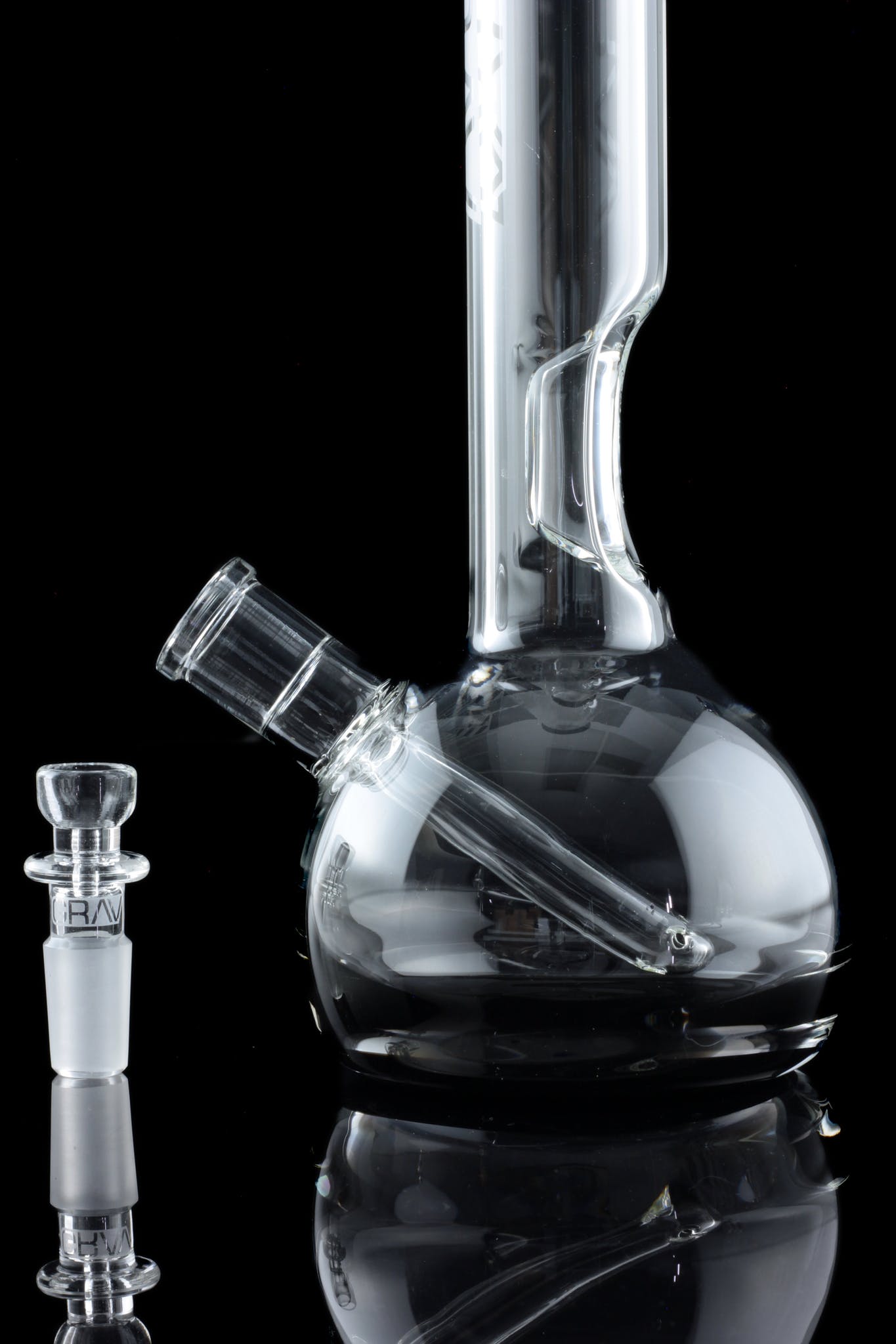 Clear glass bong and bowl with reflective surface, isolated on black.