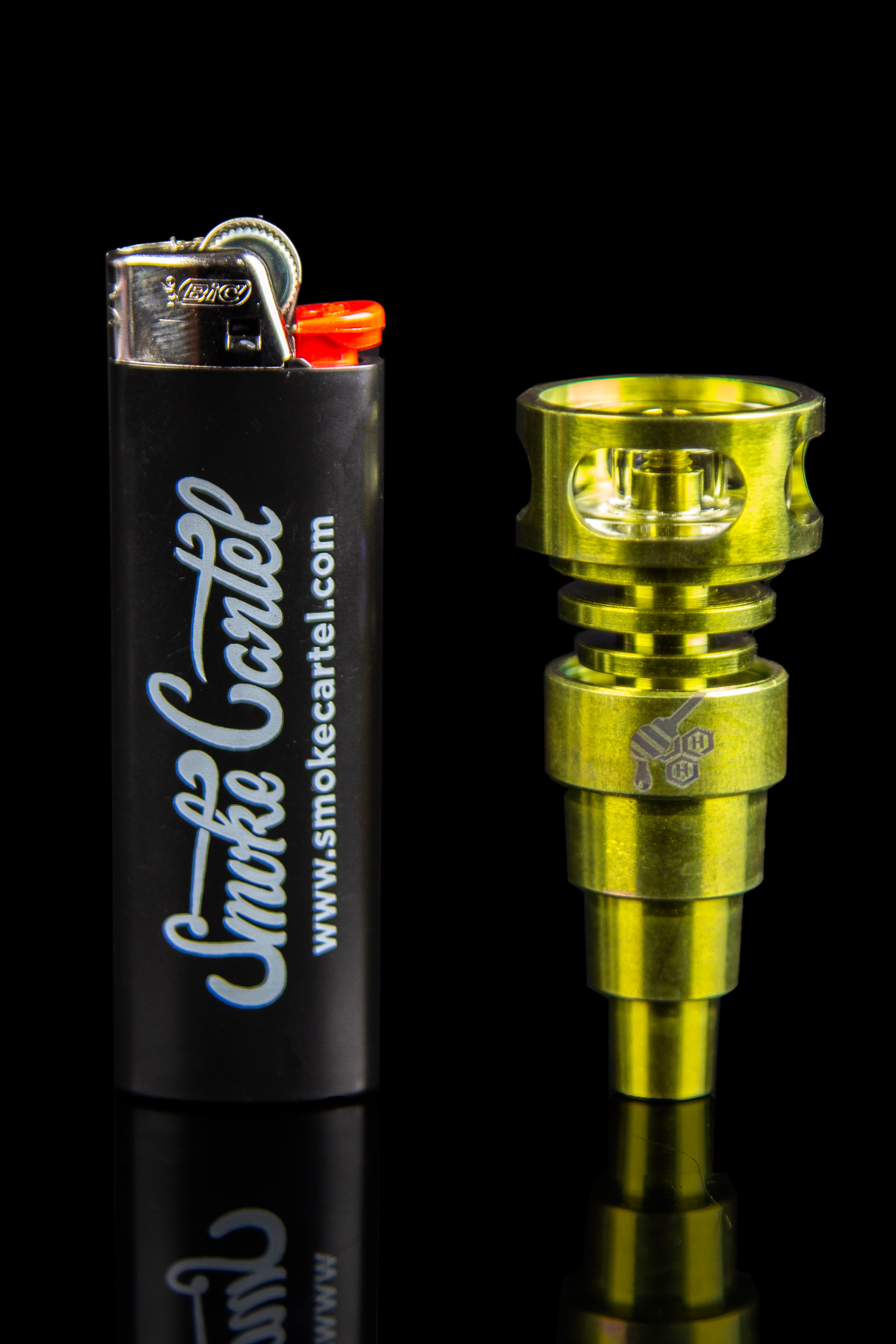 Gold cannabis oil burner and black lighter with “Smoke Cartel” branding against a black background.