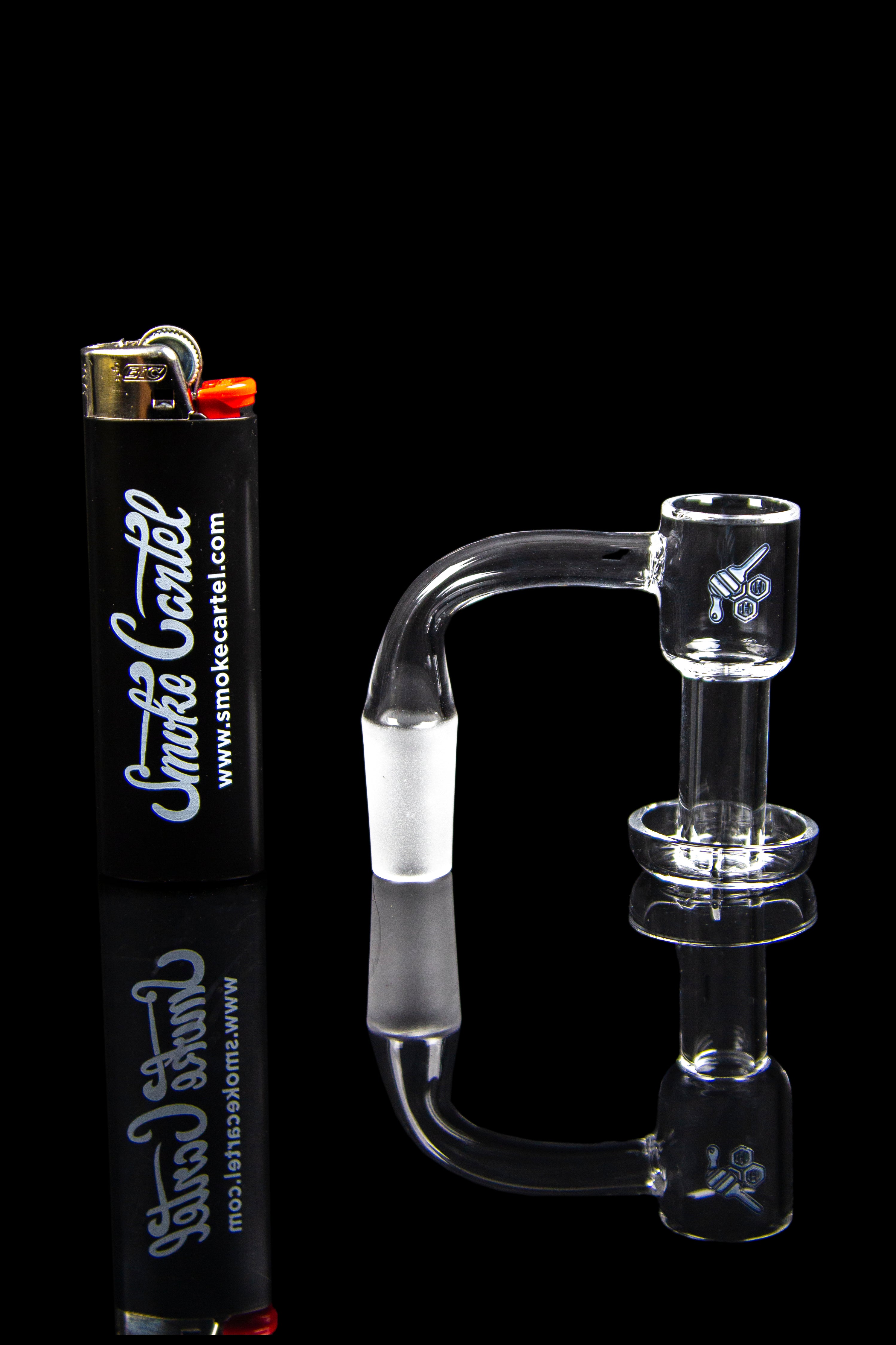 Clear glass dab rig with a quartz banger and a branded lighter.