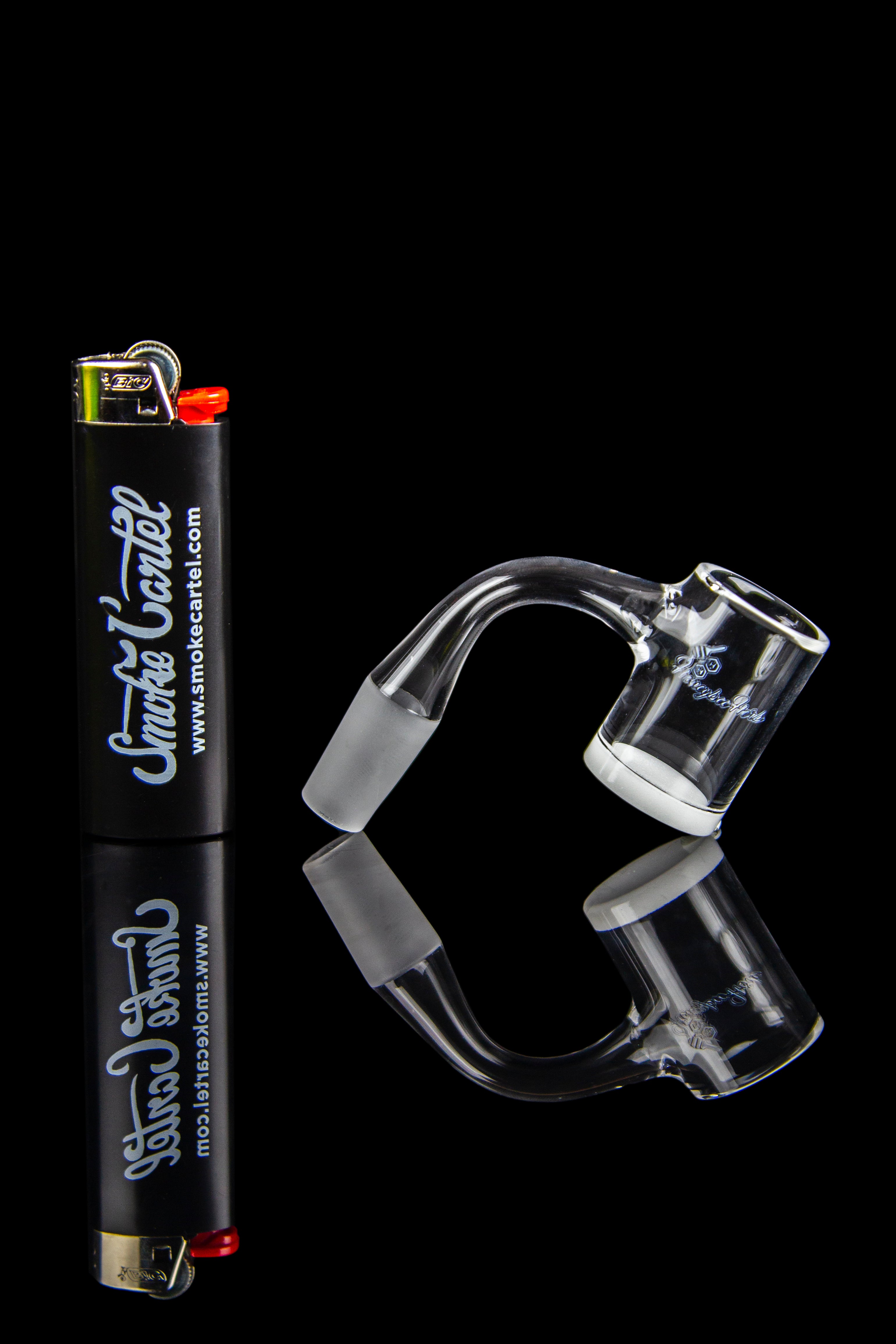 Clear glass dab rig and accessories with a lighter, on a black background.