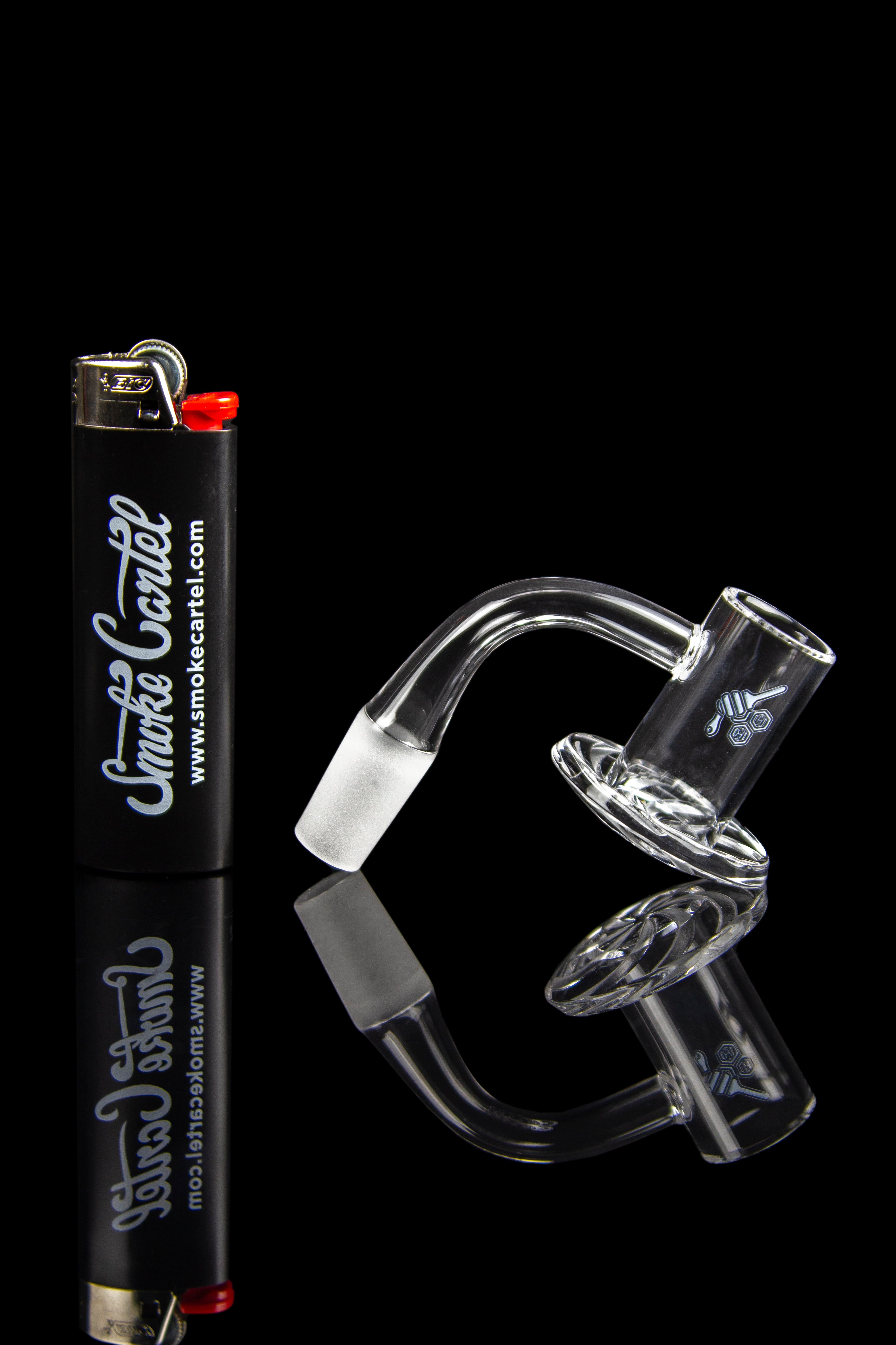 Clear glass dab rig with accessories and lighter on a black background.