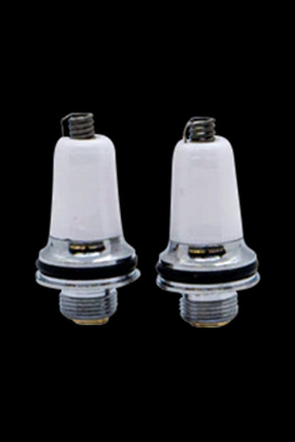 Two white ceramic cannabis oil cartridges with metal bases and mouthpieces against a black background.