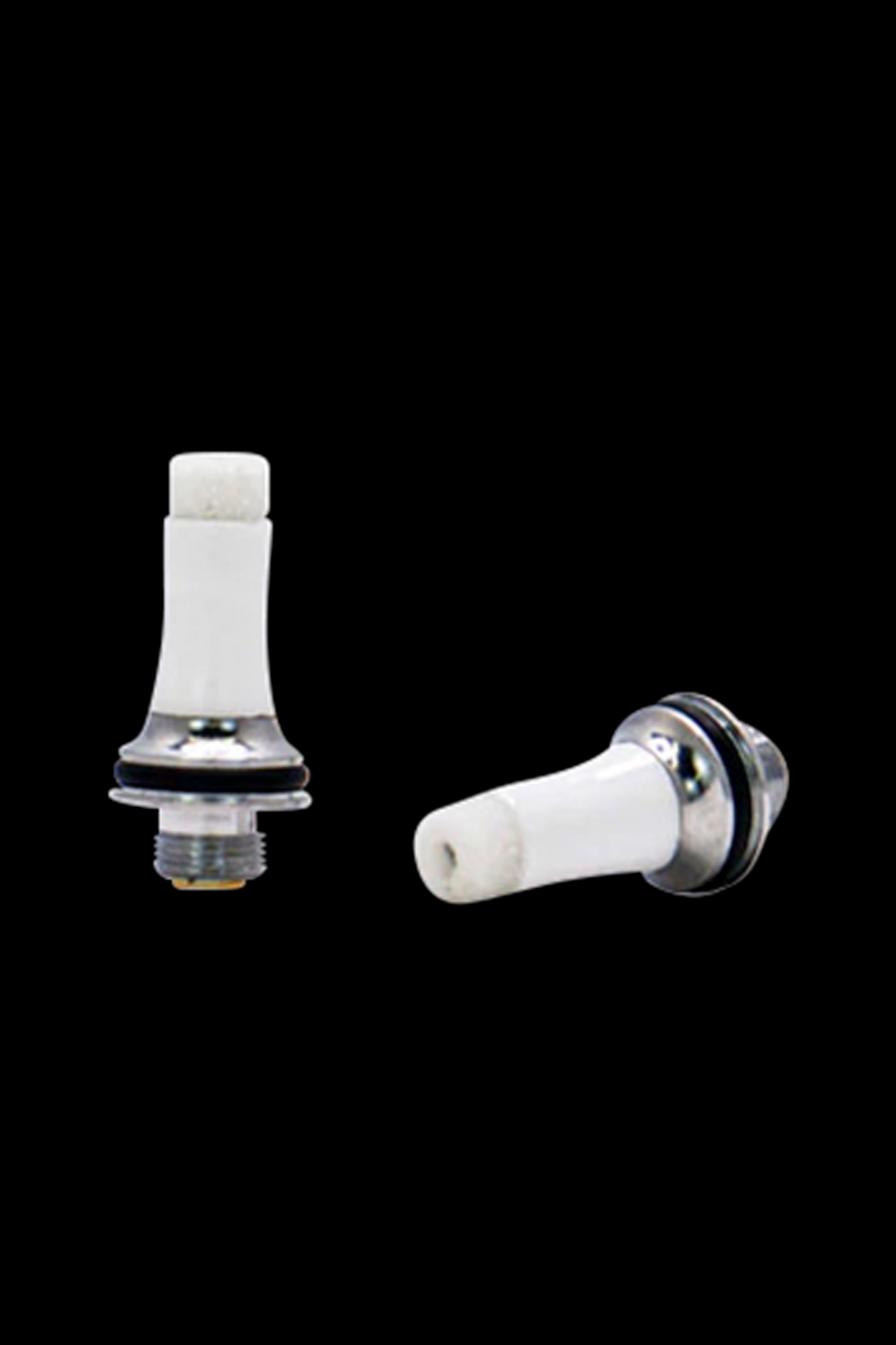 White ceramic cannabis oil vape cartridge tips with metal bases on a black background.