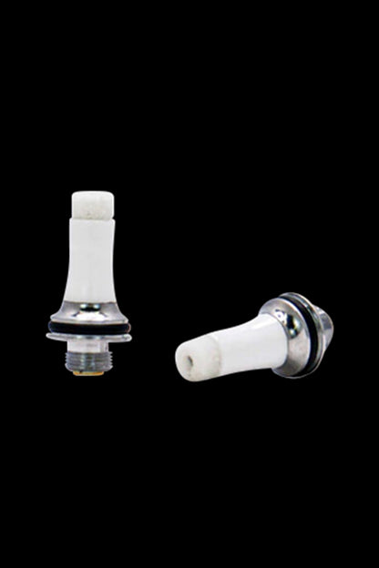 White ceramic cannabis oil vape cartridge tips with metal bases on a black background.