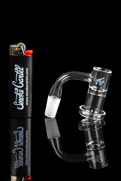 Glass dab rig and lighter with branding for Smoke Cartel, reflected on a dark surface.