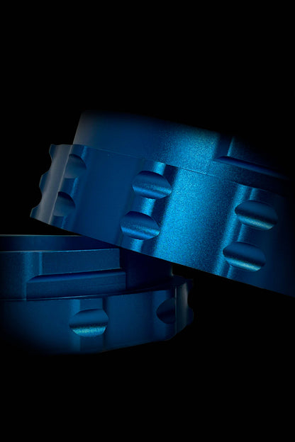 Blue cannabis grinder components arranged on a dark background.