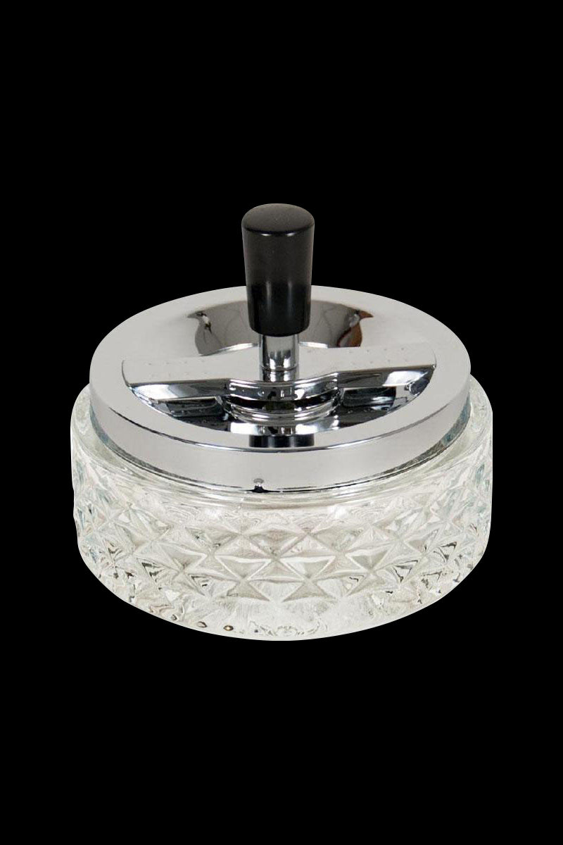 A close-up, angled view of the Glass Spinning Ashtray, showcasing its clear glass construction and circular design.