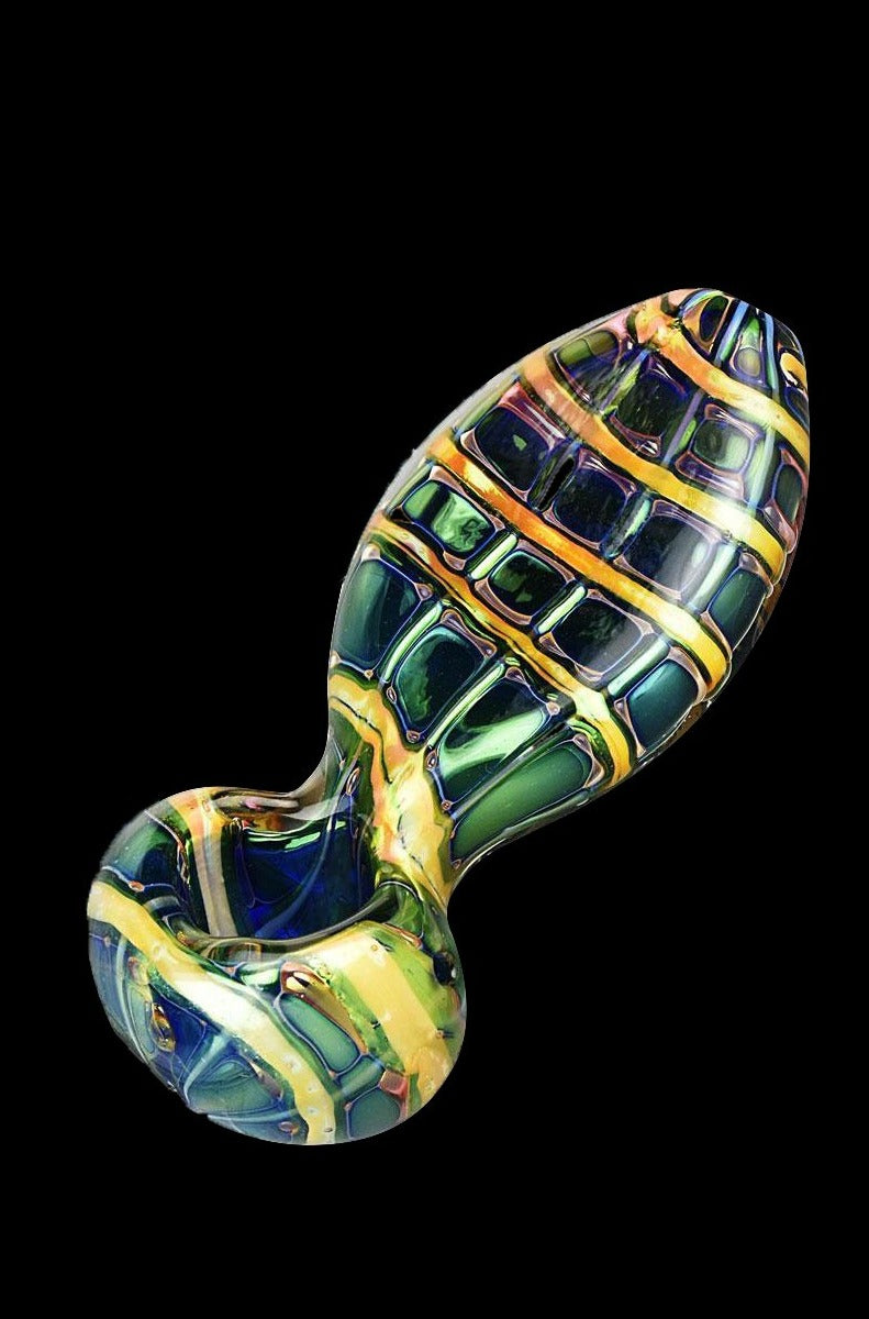 Hand-blown glass cannabis pipe with a green and gold geometric pattern.