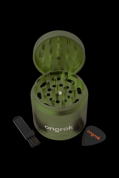 Green cannabis grinder with cleaning brush and scoop, branded “onrok”.