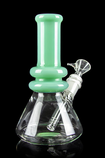 Green glass water pipe (bong) with white accents, studio shot on a reflective surface.