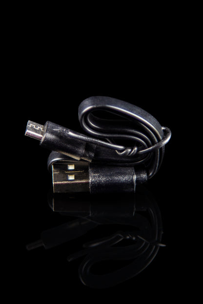 USB charger for a cannabis vape pen, isolated on black.