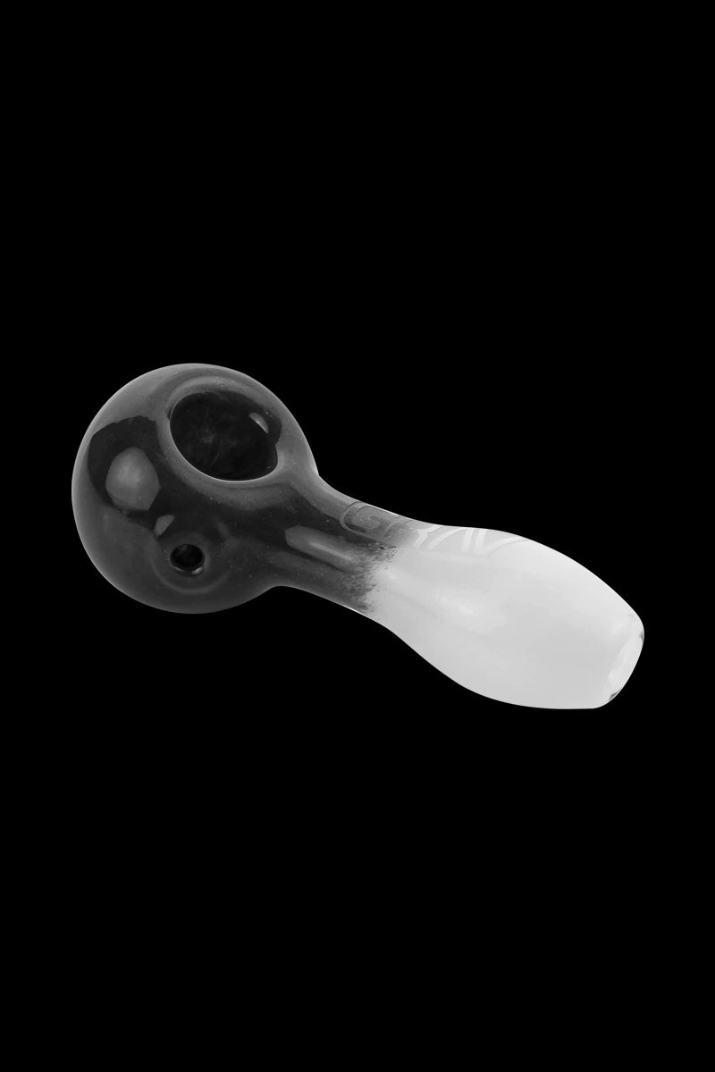 A close-up, angled view of the GRAV® Frit Spoon, showing the dark, speckled glass and curved bowl design.