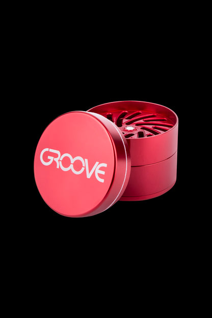 Red four-piece metal cannabis grinder with “GROOVE” logo.