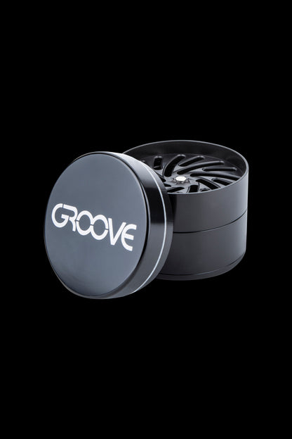 Black metal cannabis grinder with “GROOVE” logo.
