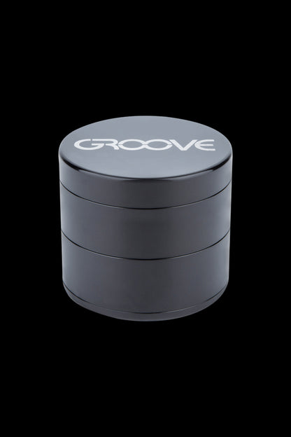 Black four-layer cannabis grinder with "GROOVE" logo on the lid.