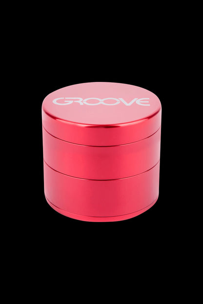 Red four-piece cannabis grinder with "GROOVE" logo.