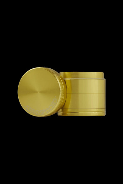 Gold cannabis grinder with open lid.