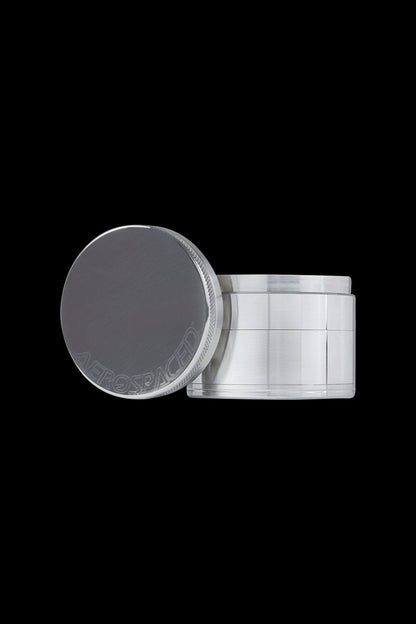 Silver cannabis concentrate container with lid askew, revealing dark contents.