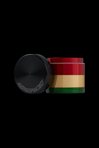 Rasta-colored cannabis grinder with a black lid featuring the brand ""Aerospace""."