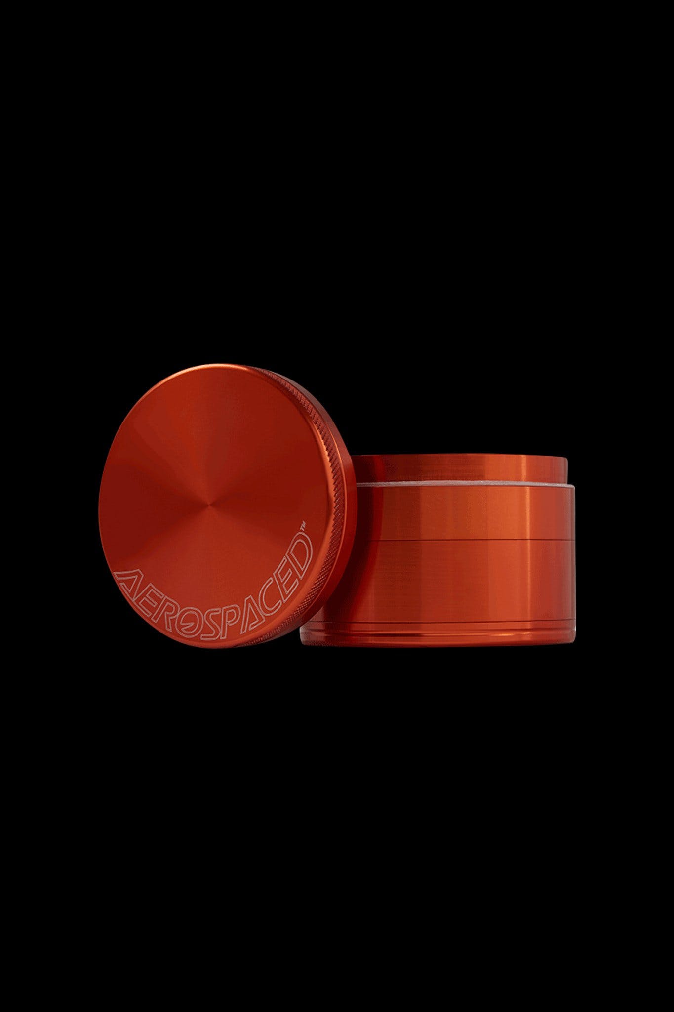 Red four-piece metal grinder with “AEROSPACED” logo, open with lid beside it.